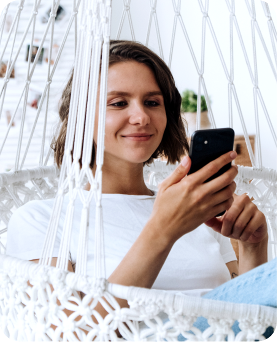 women in comfy swing viewing product samples on her phone